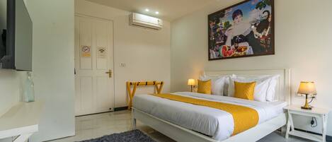 A hotel room with a bed, bedside lamps, a painting, and a television.