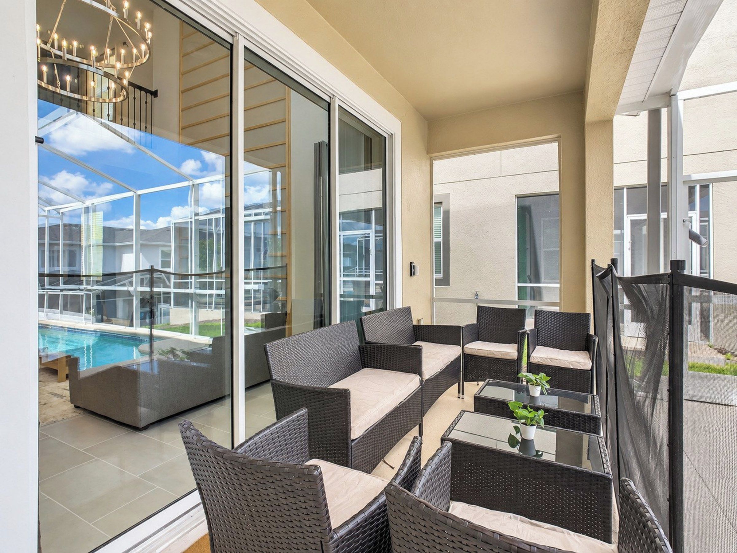 A modern outdoor seating area with wicker furniture and a pool view.