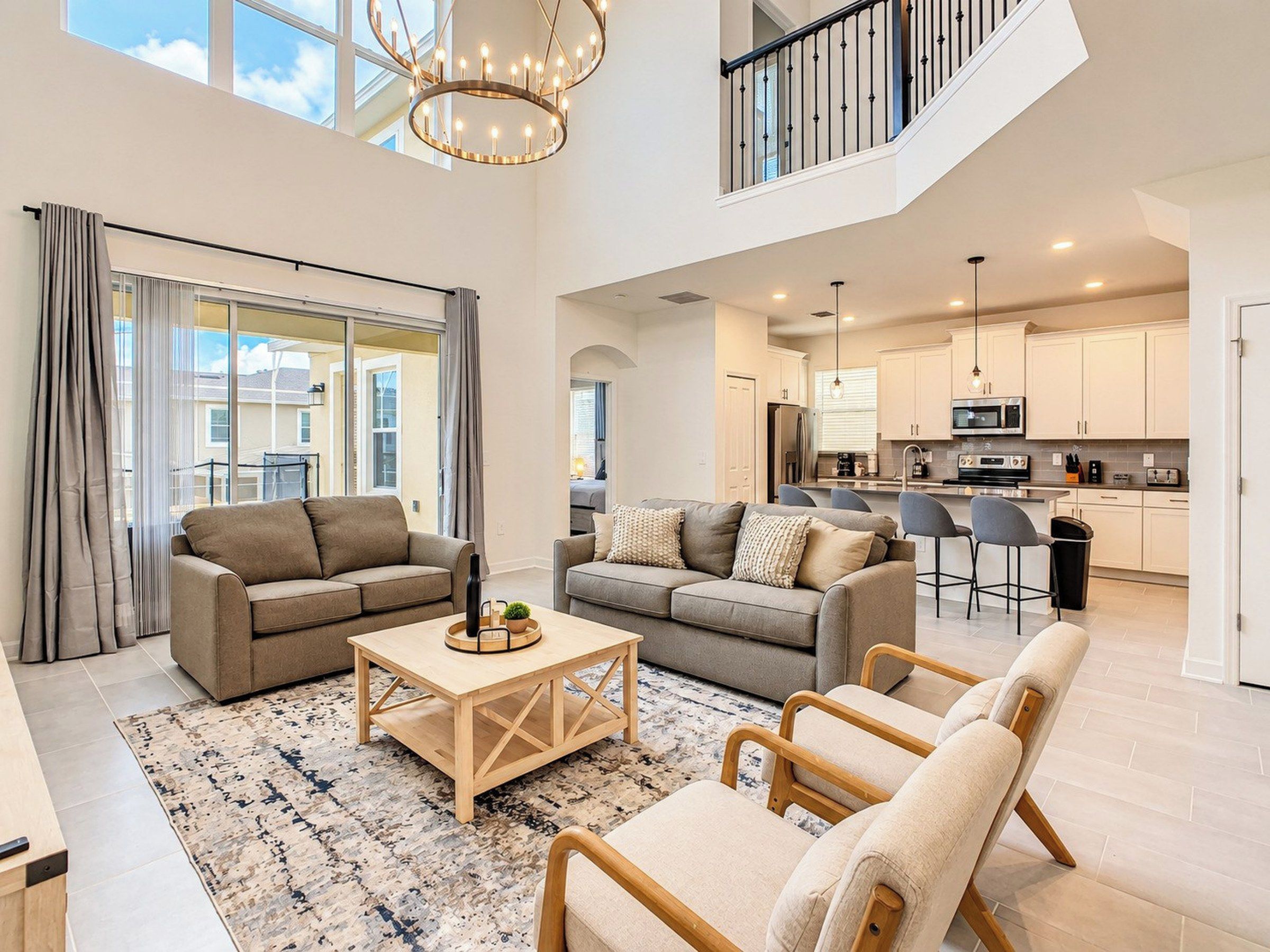 A spacious living area with a high ceiling, a dining area, and a kitchen with modern appliances.