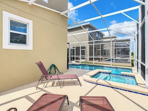 A pool area with lounge chairs, a glass-enclosed structure, and a clear sky. - Sunny Escape/ Private Pool, Jacuzzi & Waterpark (Davenport)