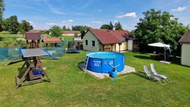 Takapiha, jossa on uima-allas, trampoliini ja pieni mökki.