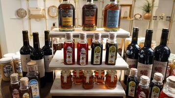 Une exposition de différentes bouteilles de miel et de liqueurs, présentées sur des étagères.