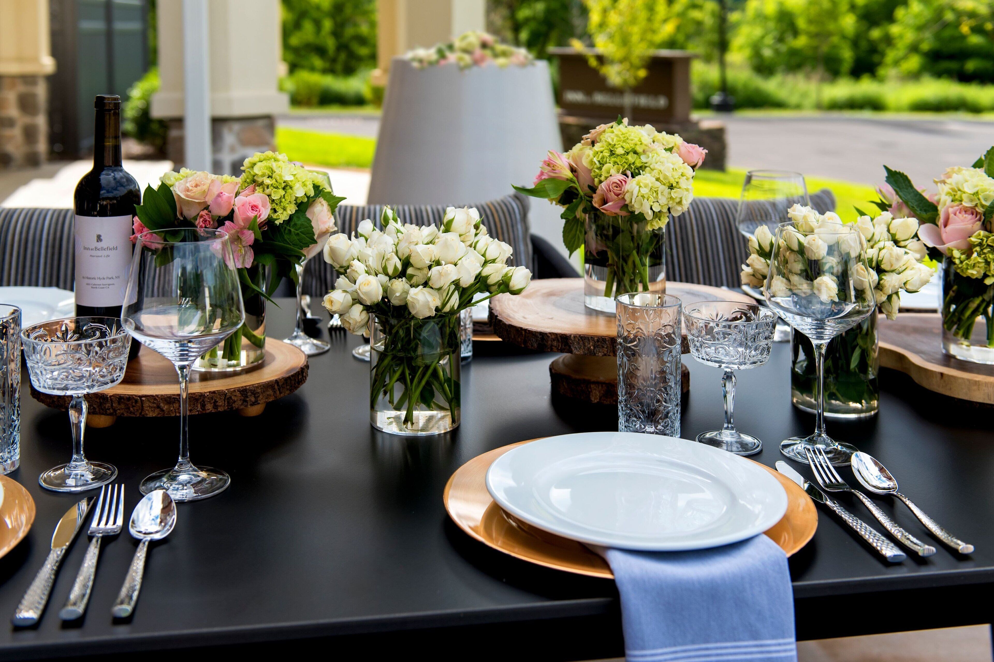 Ett dukat bord för en måltid med vinglas, tallrikar, bestick och blomsterarrangemang som mittpunkt.