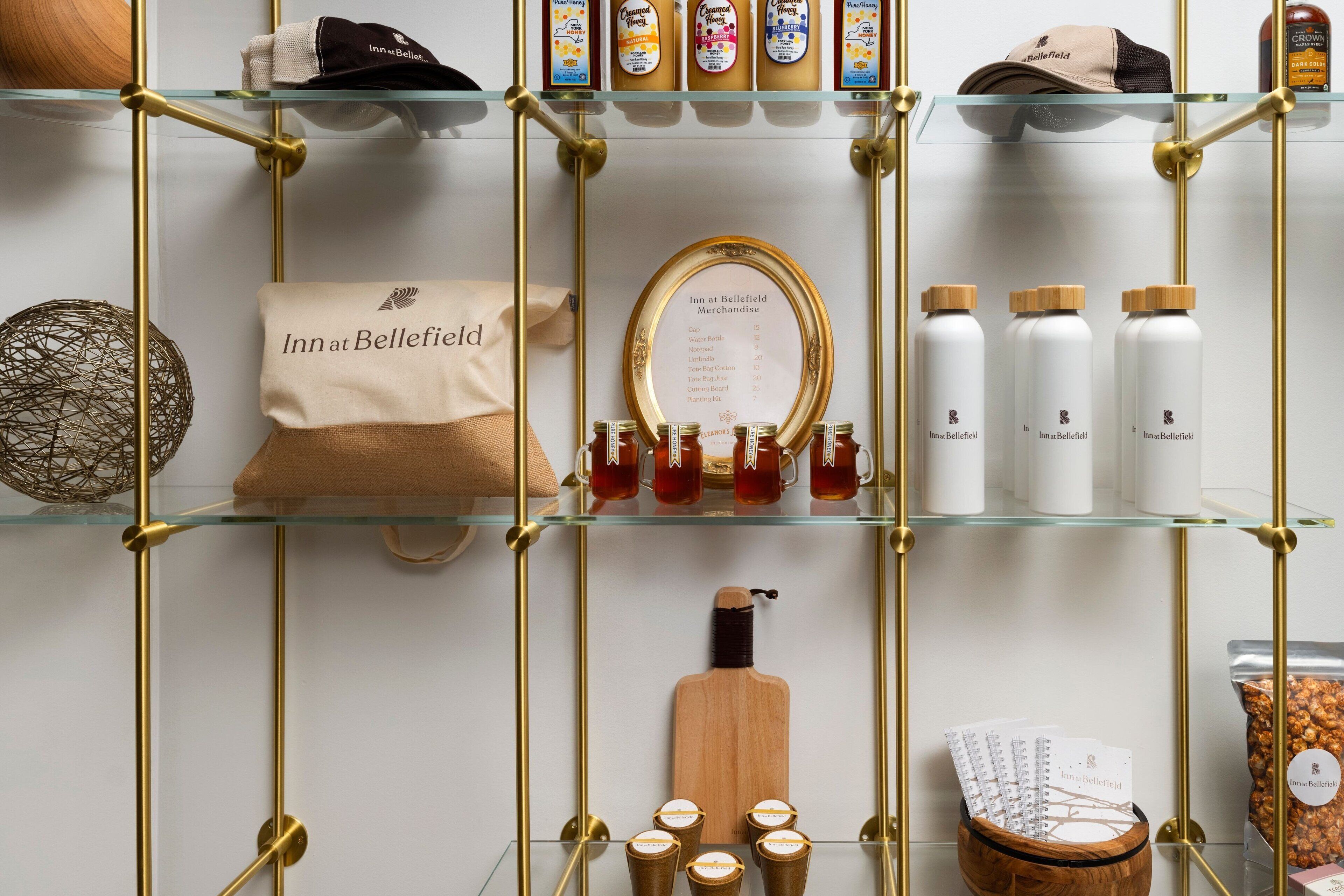 A display of Inn at Bellefield merchandise including a menu, tea mugs, and toiletries.