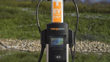 An EV charging station with a digital display, branded with 'chargepoint+' and labeled 'EV CHARGING ONLY'.