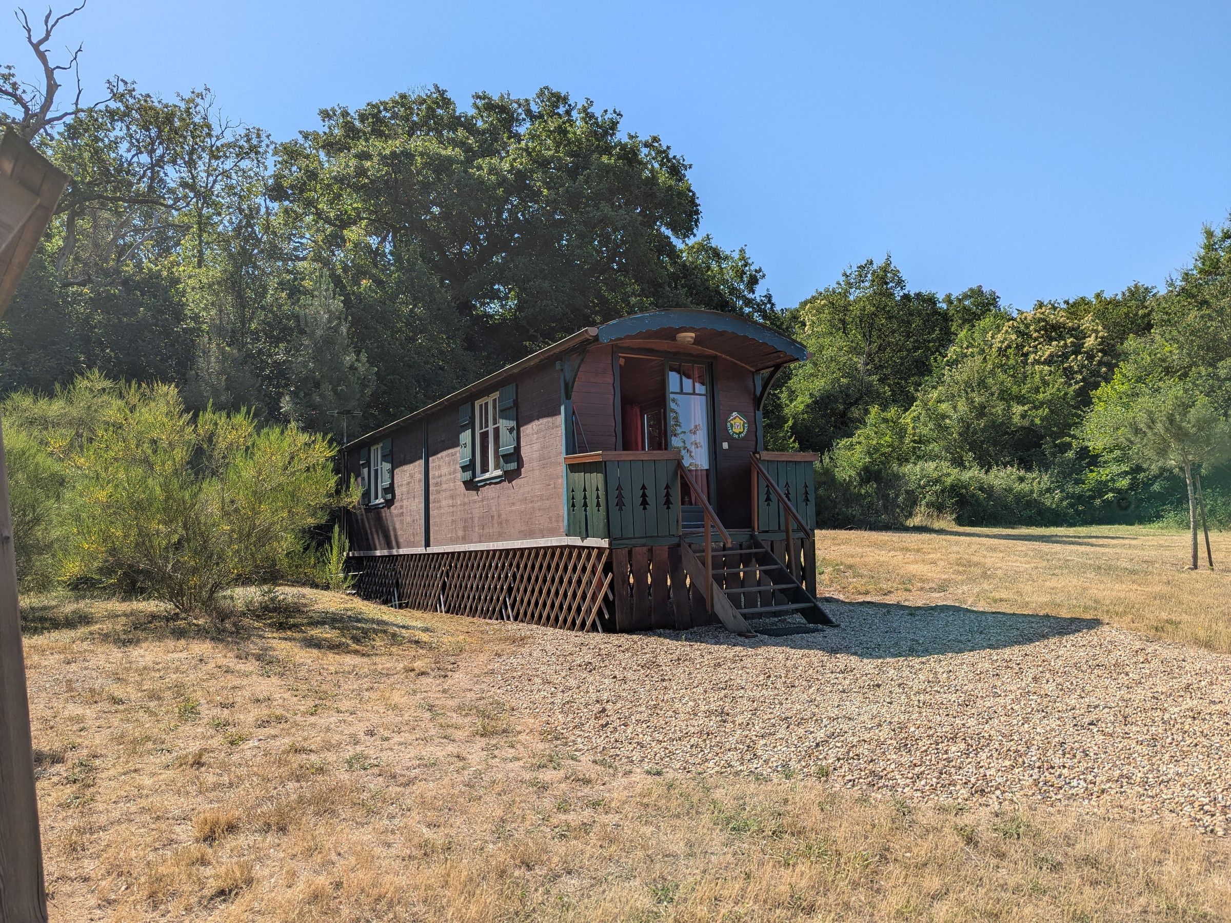 Une cabane en bois avec une véranda et un petit escalier.
