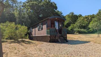 Une cabane en bois avec une véranda et un petit escalier.