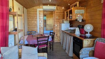 Een gezellig interieur van een chalet met een eethoek, keuken en zithoek.
