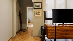 A modern living room with a wooden cabinet, a flat-screen TV, and a hallway leading to another room. - w* | Stylish 2BR in Cuauhtemoc (Ciudad de México)