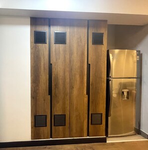 A wardrobe with a mirrored closet door and a built-in refrigerator. -  Aparts4Days Executive Apartment San Isidro Business (Lima)