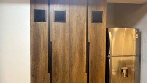 A wardrobe with a mirrored closet door and a built-in refrigerator. -  Aparts4Days Executive Apartment San Isidro Business (Lima)