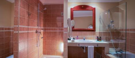 A modern bathroom with a glass-enclosed shower, a white sink, and a large mirror above the vanity.