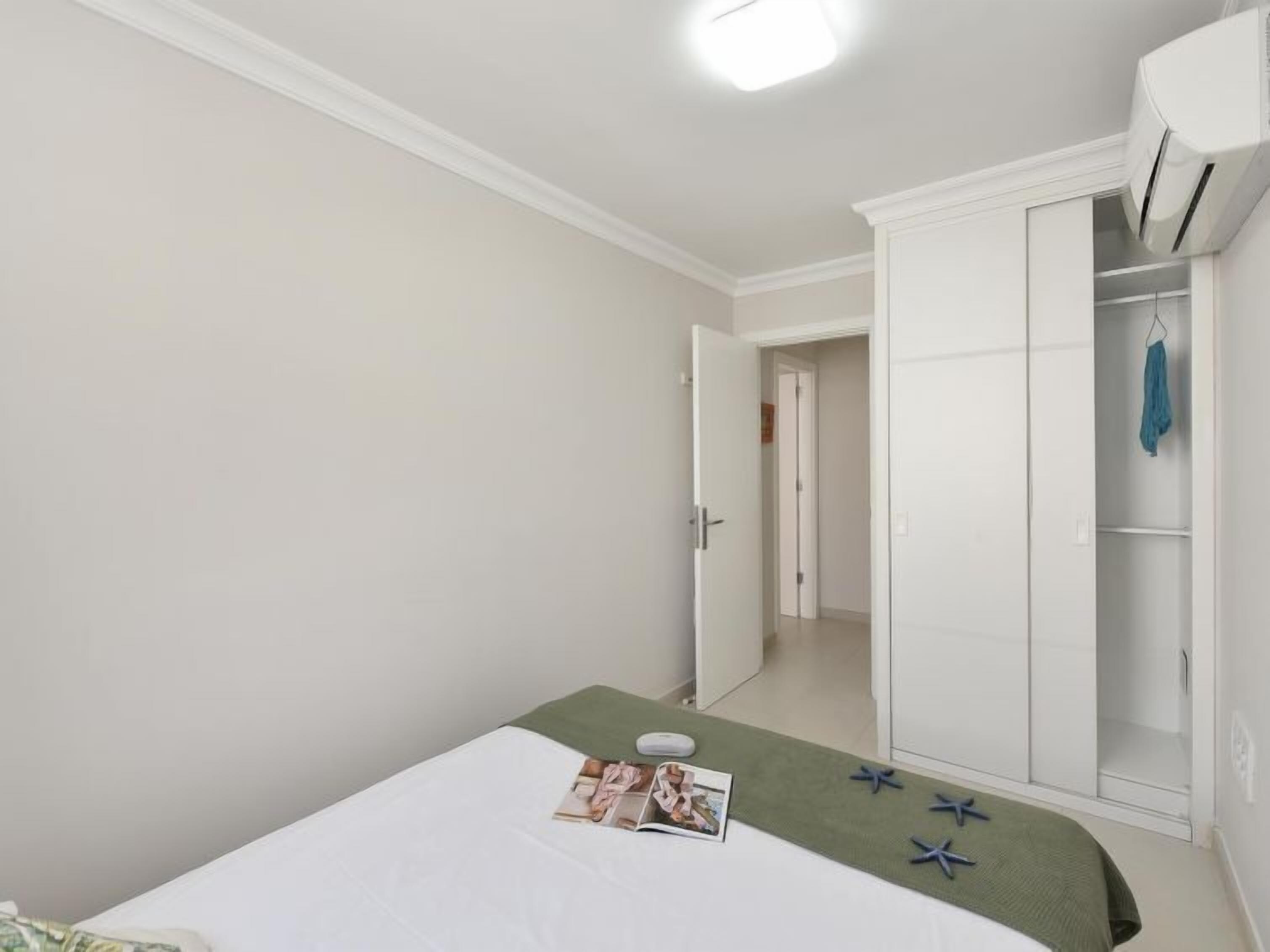 Una camera da letto con un letto, un armadio e una porta che dà su un'altra stanza.