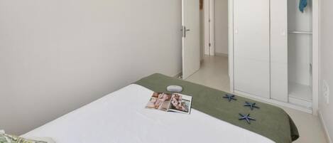 Una camera da letto con un letto, un armadio e una porta che dà su un'altra stanza.