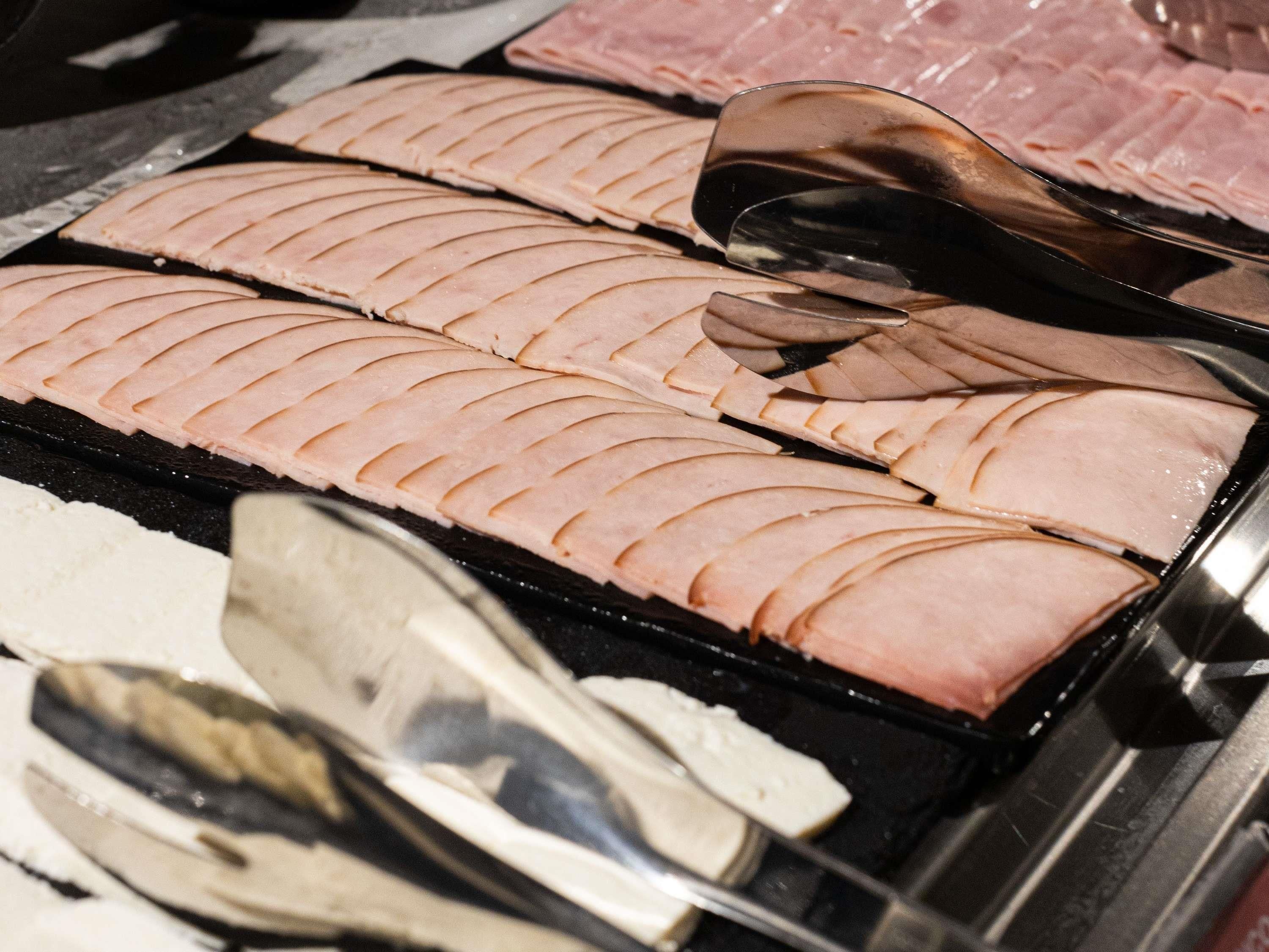 A display of sliced meat arranged in a grid pattern on a tray.