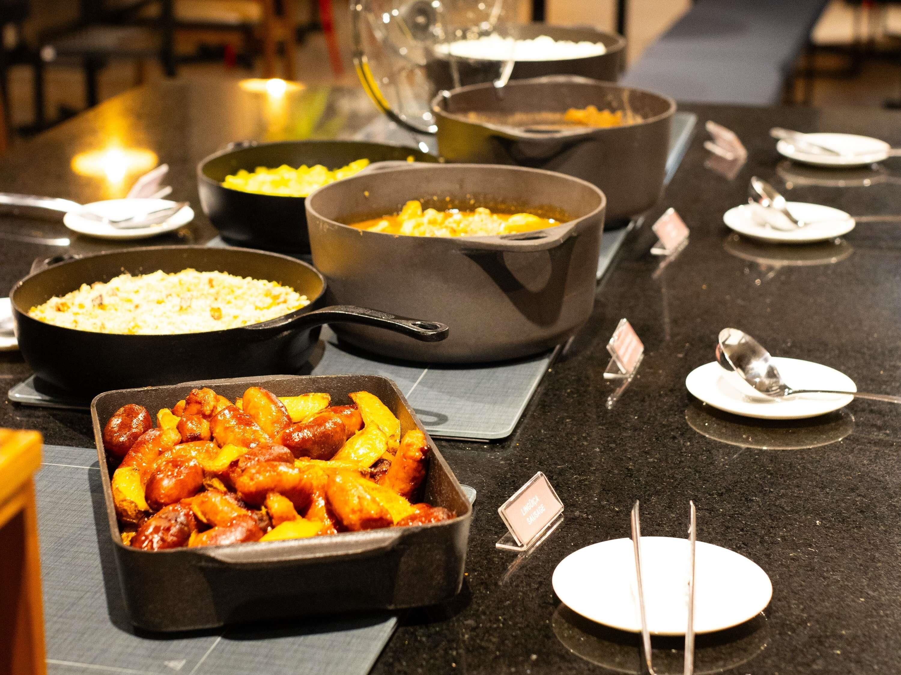 Ein reichhaltiges Buffet mit verschiedenen Speisen, darunter eine Auflaufform, Reis und eine Portion Fleisch mit Gemüse.