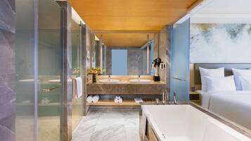 Un baño moderno con una bañera grande, dos lavabos y una cabina de ducha de vidrio.
