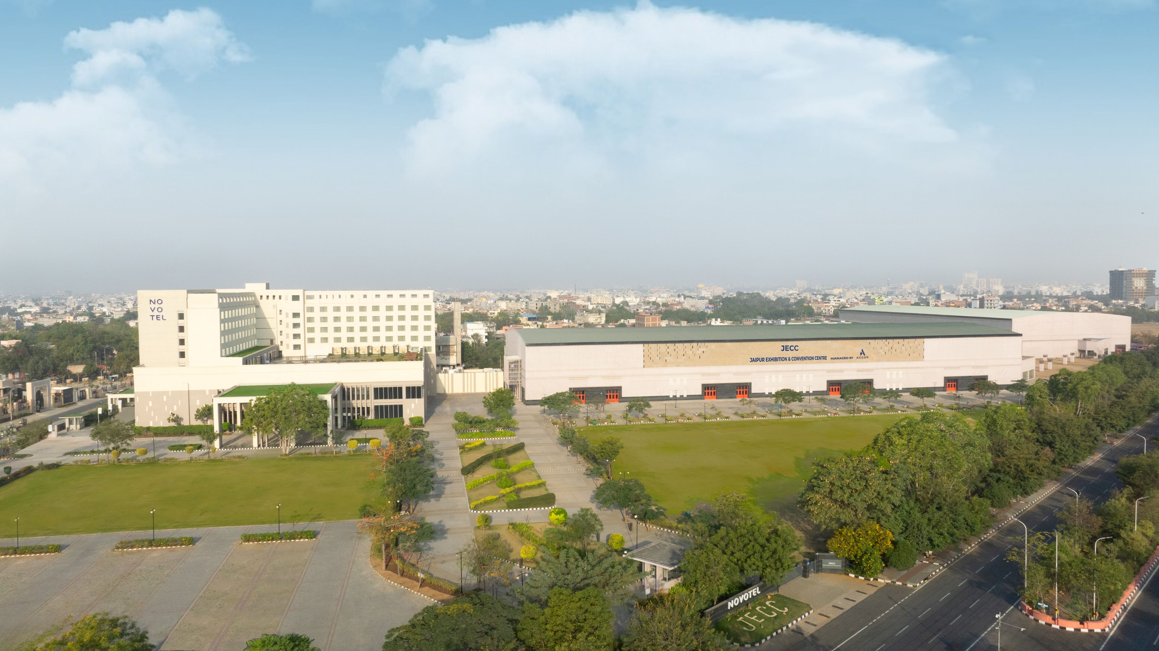 A modern hotel with a flat roof, multiple floors, and a spacious courtyard.