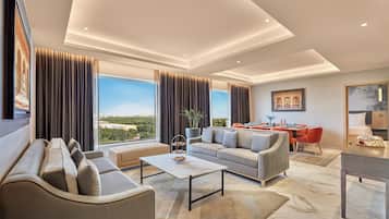 A modern living room with a sofa, a coffee table, and a dining area with a table and chairs.