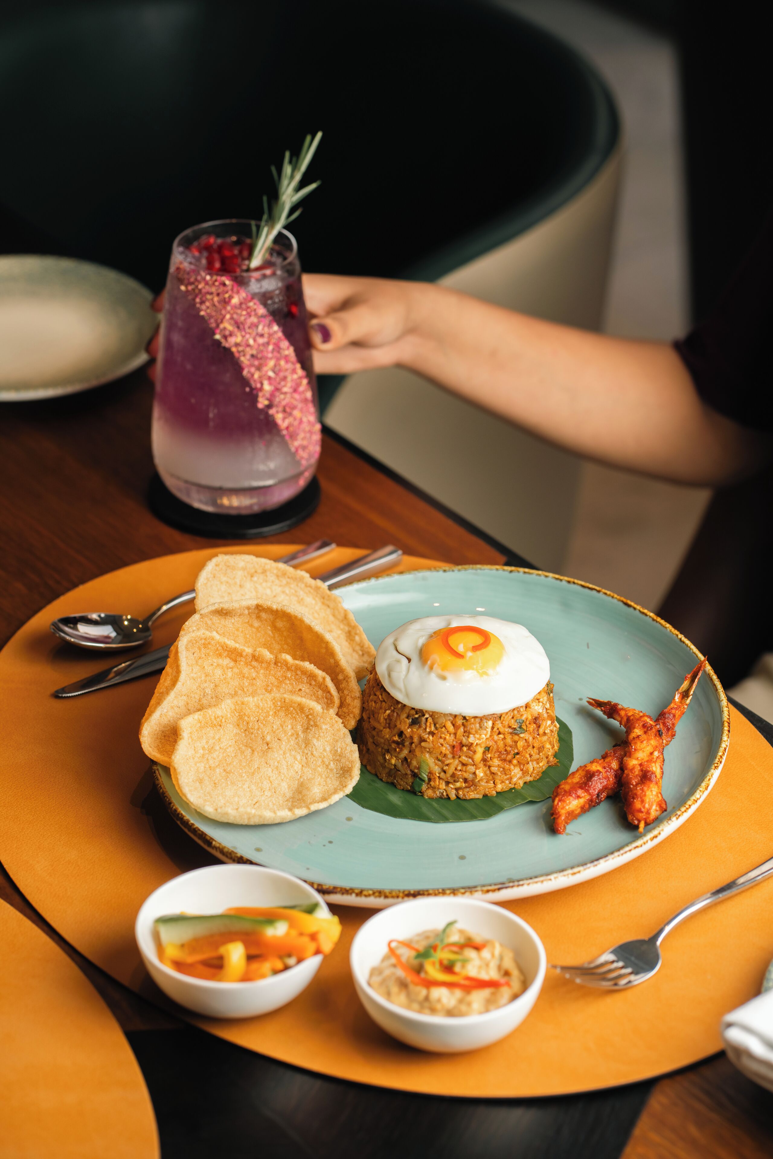 A plate with fried rice, a fried egg, and a side of crispy chicken wings.
