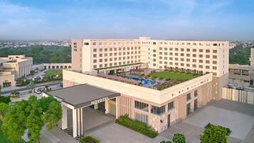 A large hotel with a central courtyard, multiple floors, and a prominent entrance.