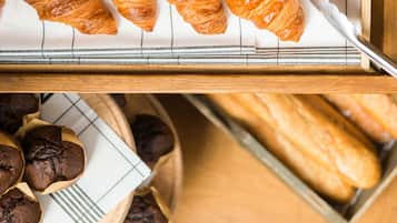 Una bandeja con cruasanes y muffins sobre una superficie de madera.