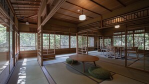 A traditional Japanese room with tatami flooring, sliding doors, and a low table with cushions. - ThinkStay Mt. (Kobe)