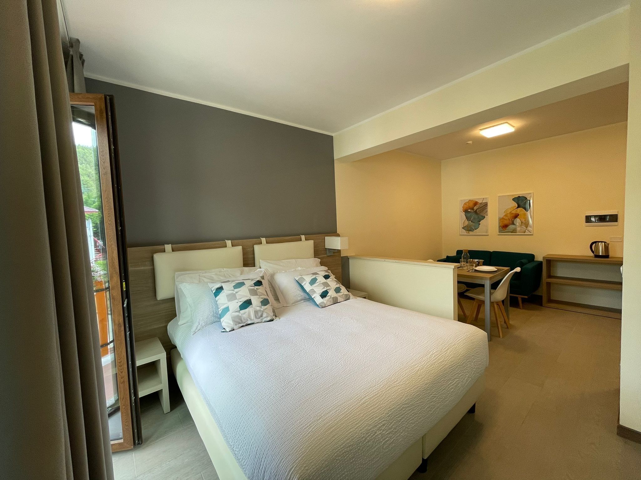 A bedroom with a bed, a desk, and a chair.