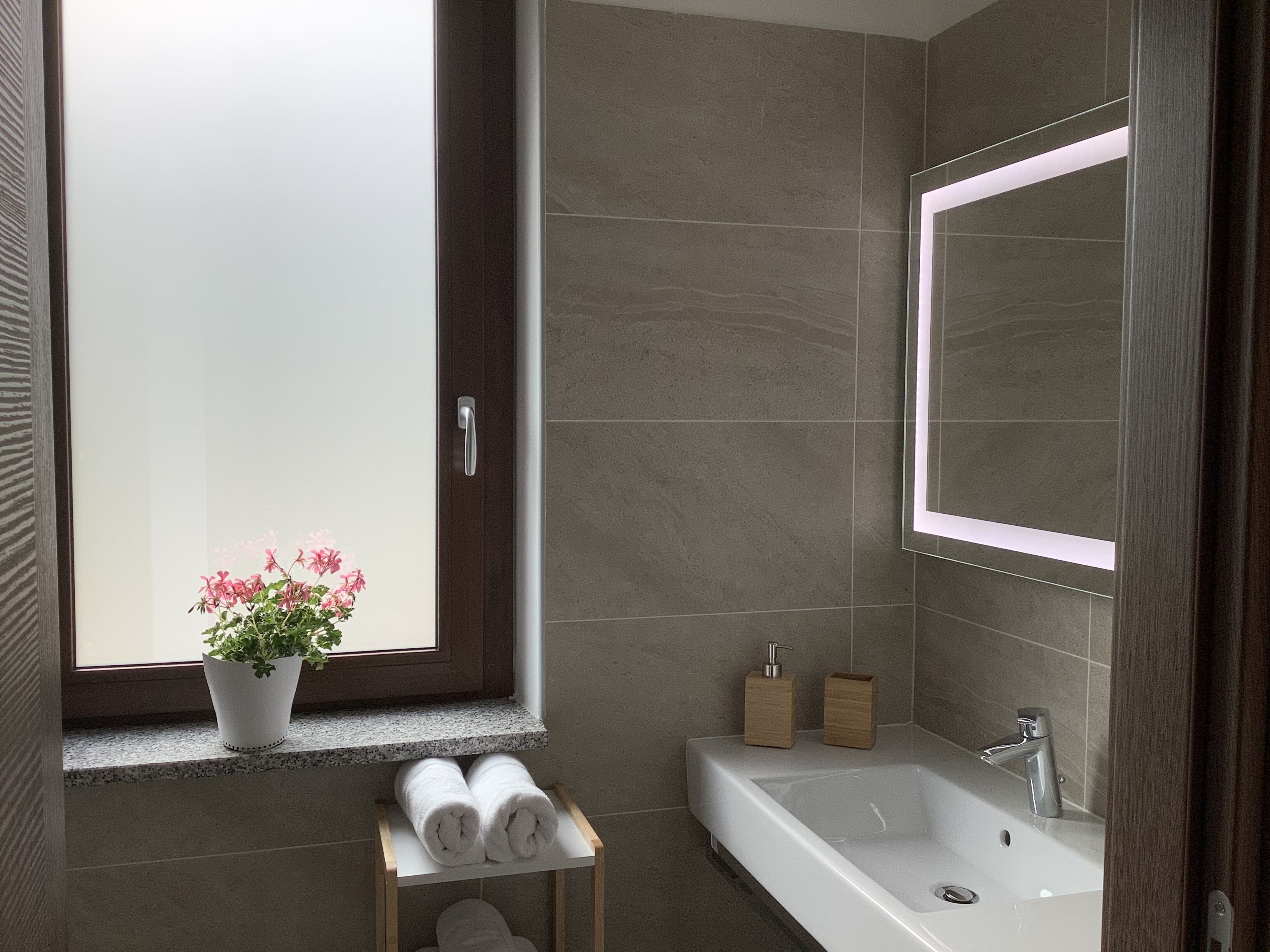 Une salle de bain moderne avec une grande baignoire, une fenêtre offrant une belle vue et une plante en pot.