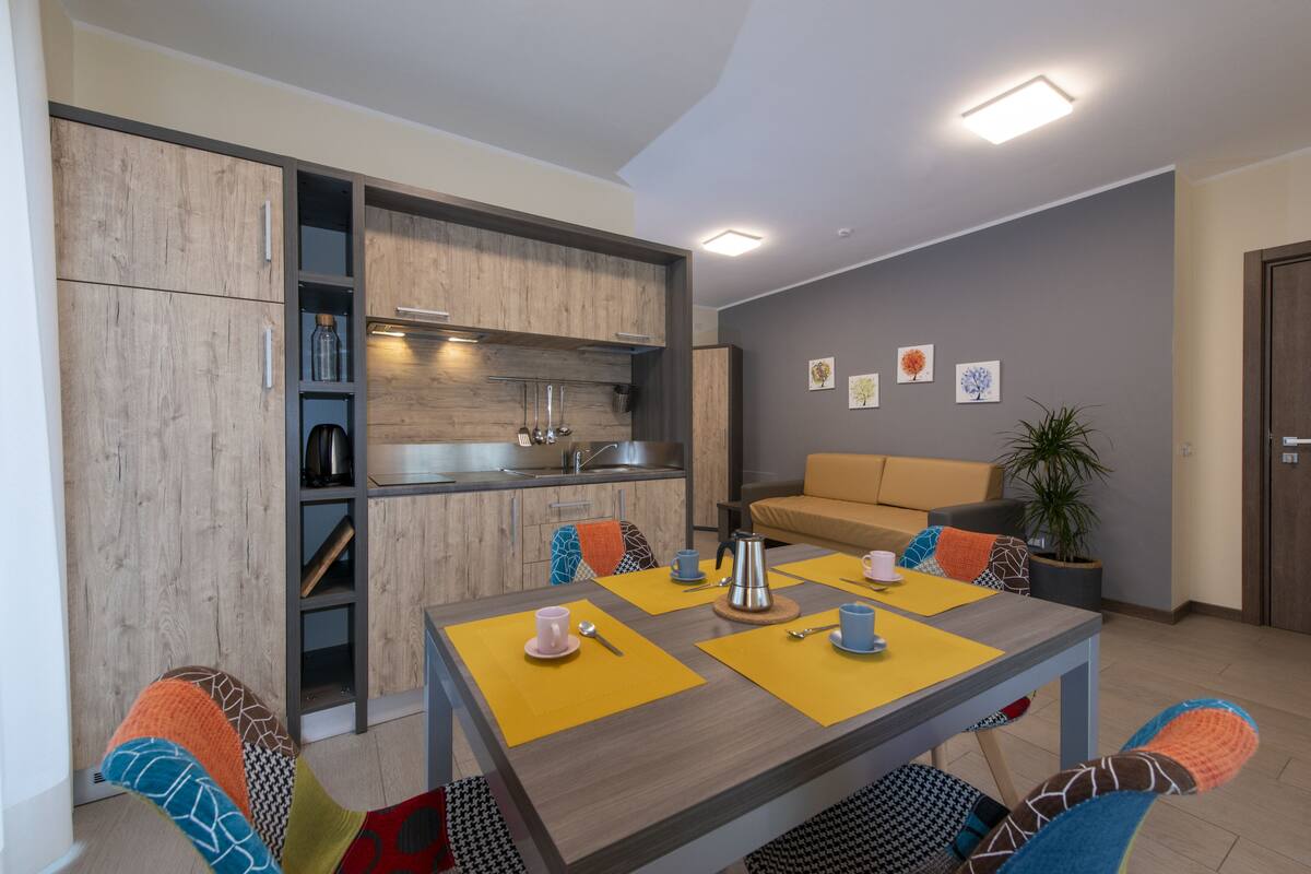 Una sala de estar moderna con mesa de comedor, sofá y zona de cocina.