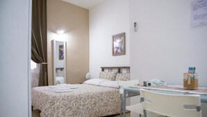 A bedroom with a bed, a bedside table, a chair, a mirror, and a framed picture on the wall.