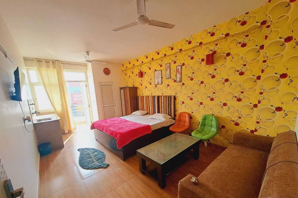 Un dormitorio con cama, escritorio, silla y sofá.