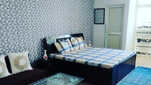 Un dormitorio pequeño con una cama, una mesita y una alfombra azul.