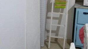 A narrow room with a white wall, a small ladder, a red box, and a white chair. - Quad room (Monopoli)