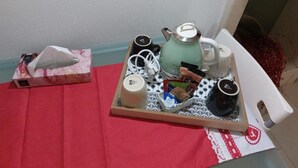 A tray with a teapot, cups, and tea bags on a table with a red cloth. - Quad room (Monopoli)