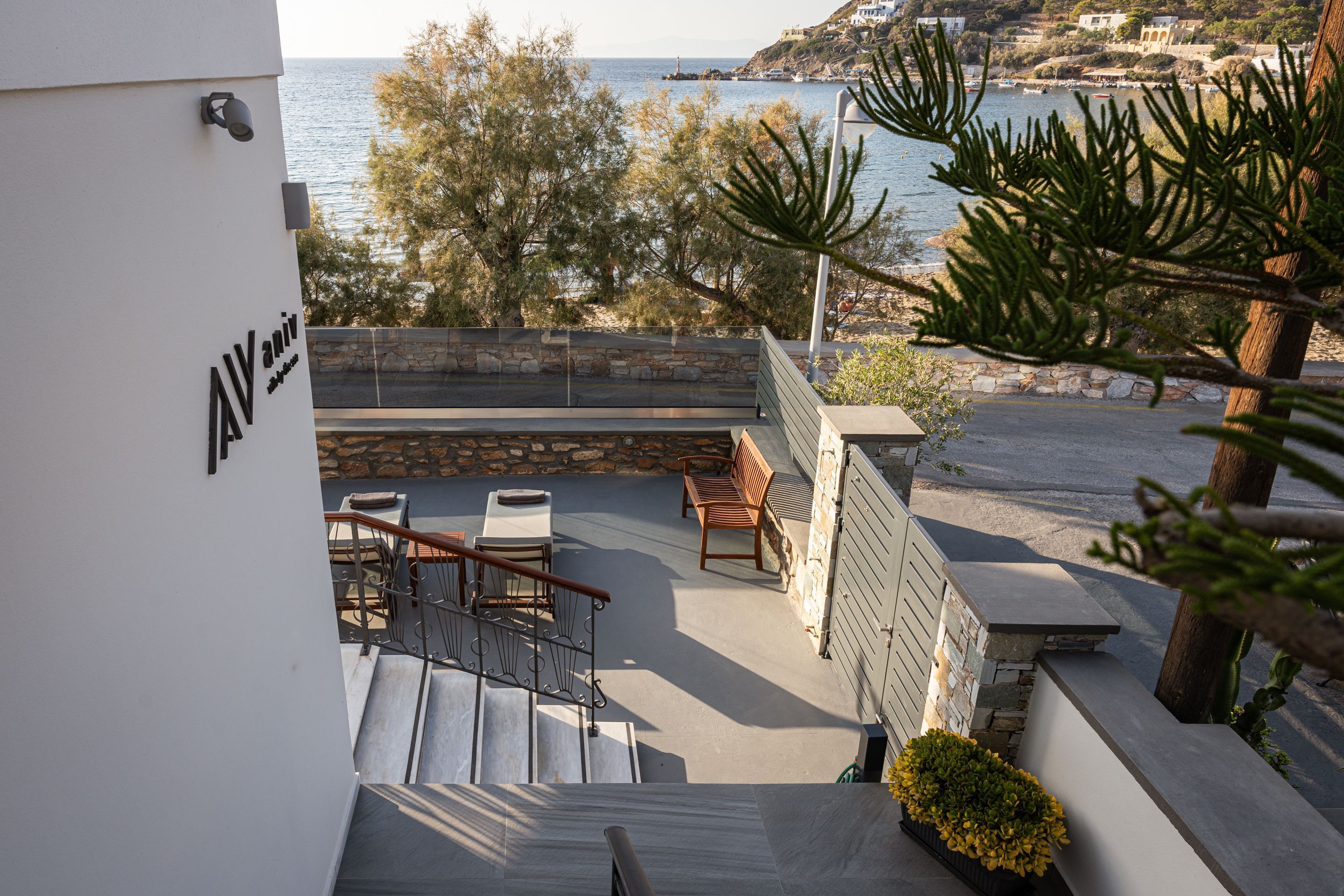 Une terrasse avec des sièges extérieurs, un mur en pierre et une vue sur la mer.