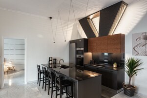 Una cocina moderna con una isla central, electrodomésticos de acero inoxidable y una planta en maceta.