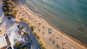 Oversigtsbillede af en strand med parasoller og mennesker.