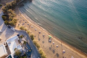 Vista aérea de una playa con sombrillas y gente.