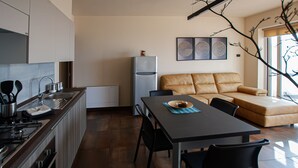 Een moderne keuken met een eethoek, een bank en een koelkast.