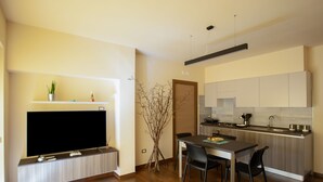Een moderne keuken met een eethoek, ingebouwde apparatuur en een flatscreen televisie.