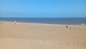 A wide sandy beach with clear blue sky and calm sea. - Chapel St Leonards Happy Days Beachfield (Mablethorpe)