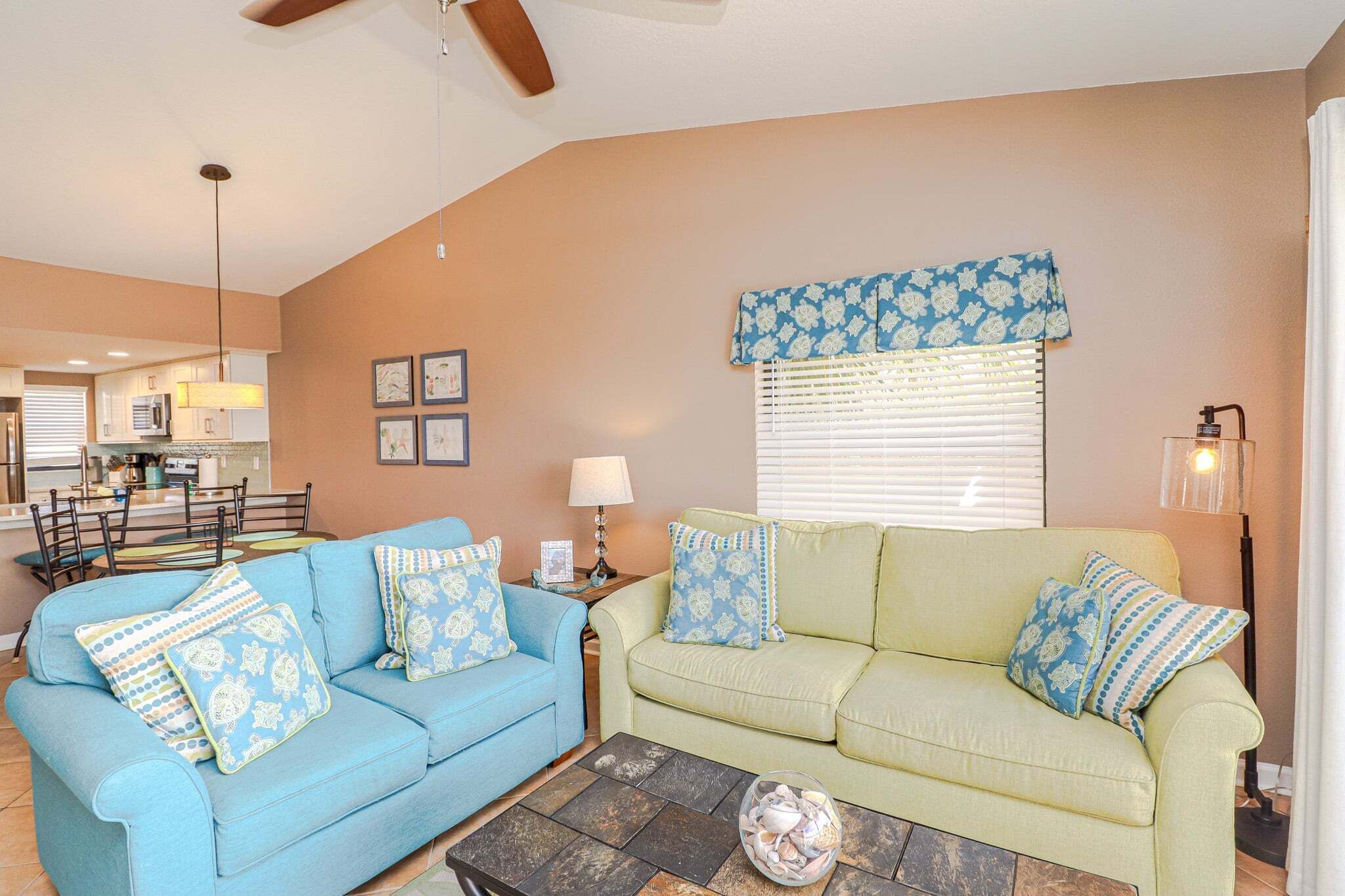 A living room with two sofas, a coffee table, and a dining area with a table and chairs.