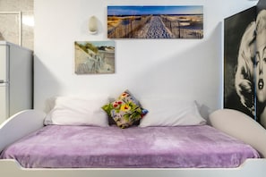 A bedroom with a bed, a pillow, and two wall-mounted pictures. - Studio Apartment with Shared Pool, Wi-Fi and Air Conditioning (La Cala del Moral)