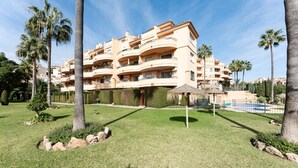 A multi-story residential building with balconies, a swimming pool, and palm trees. - Holiday Apartment "Penthouse 3-Bedroom Duplex" with Sea View, Shared Pool & Wi-Fi (Mijas)