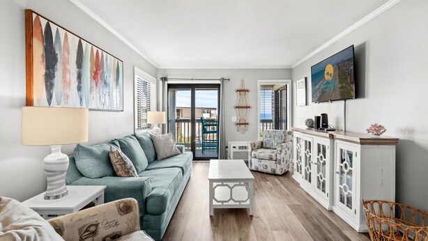 A living room with a sofa, a coffee table, a TV, and a cabinet. - Ocean Forest Villas Unit B305 - Ocean view (Myrtle Beach)