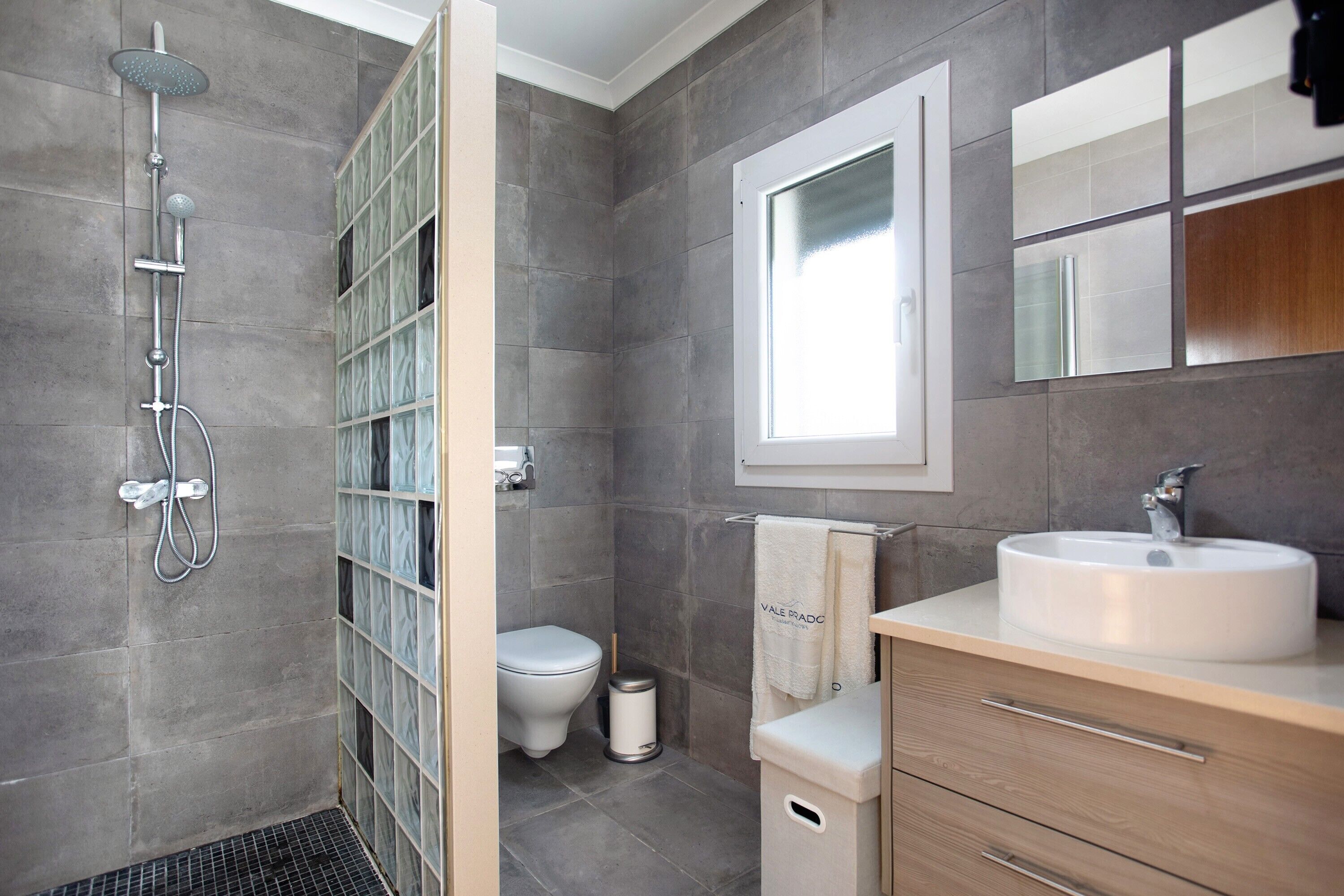 Un baño moderno con ducha, inodoro y tocador.