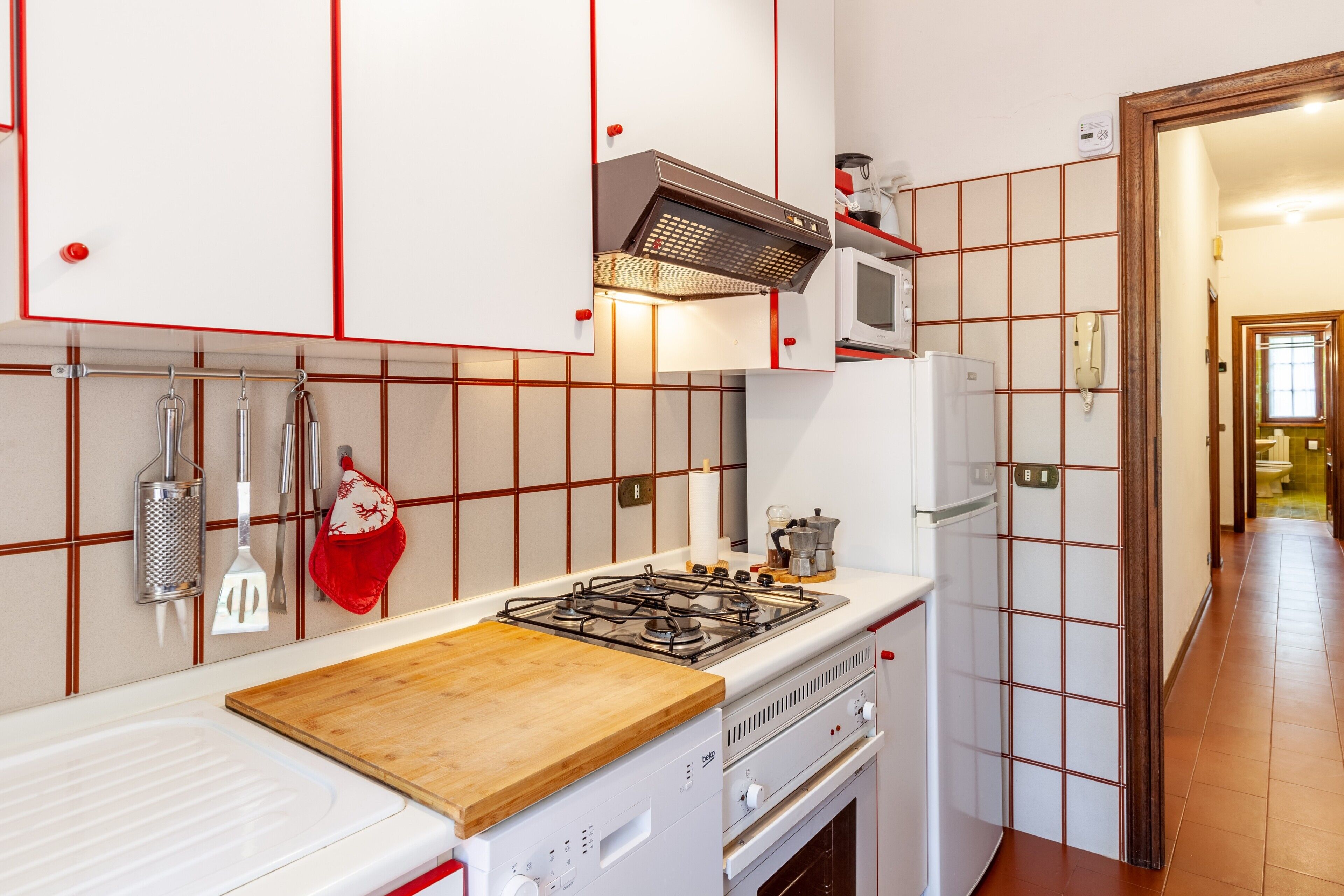 Eine Küche mit Gasherd, Mikrowelle und Backofen.