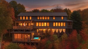 Ein mehrstöckiges Holzhaus mit Balkonen, einem Pool und Blick auf herbstliches Laub.