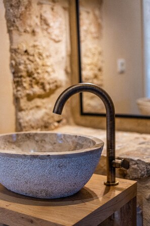 A stone basin with a curved faucet on a wooden platform. - Pyrgos Towers (West Mani)